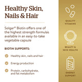 Solgar biotin cápsula junto a mano para comparar tamaño y facilidad de ingestión