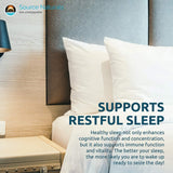 Source Naturals persona en cama con luz baja usando pastilla antes de dormir