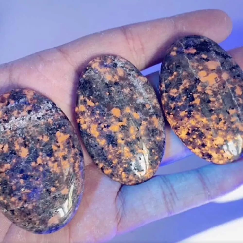 UCCKEYI Yooperlite encendida con luz UV en mano para ver fluorescencia brillante