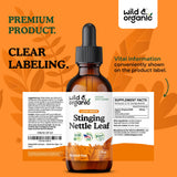 Wild & Organic hojas de ortiga frescas junto al frasco resaltan origen natural