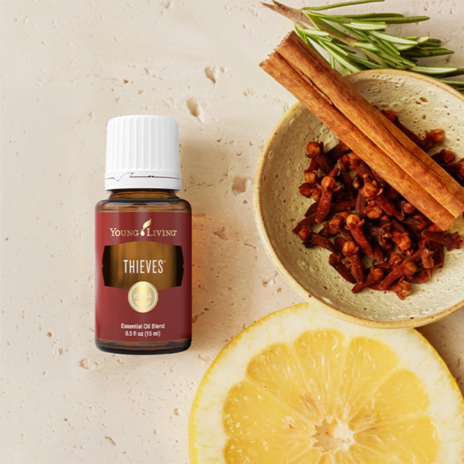 Young Living Thieves en botella junto a limpiador casero, mezcla versátil